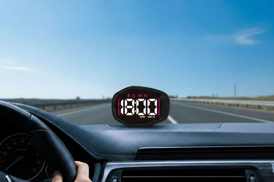 K3 GPS digital speedometer with clock display mounted on car dashboard, showing 18:00 time and ESWN compass on LED screen, highway road visible through windshield