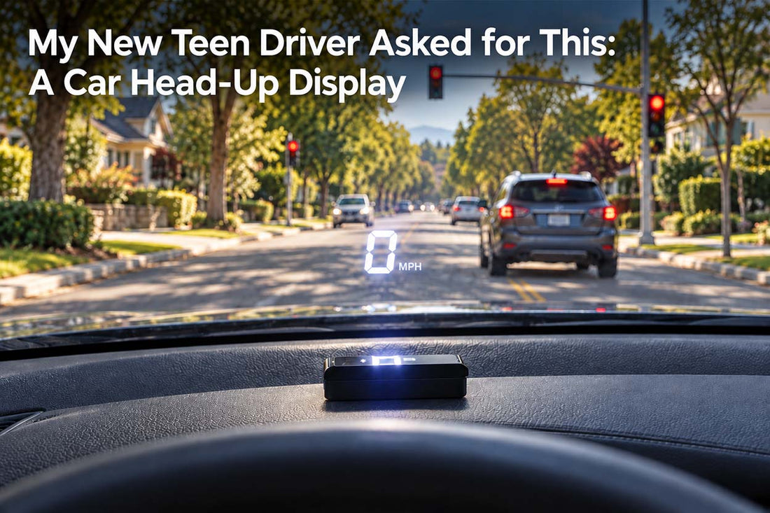 KUOWEIHUD head-up display on a car dashboard, projecting 0 MPH onto the windshield while stopped at a red light on a sunny, tree-lined street.